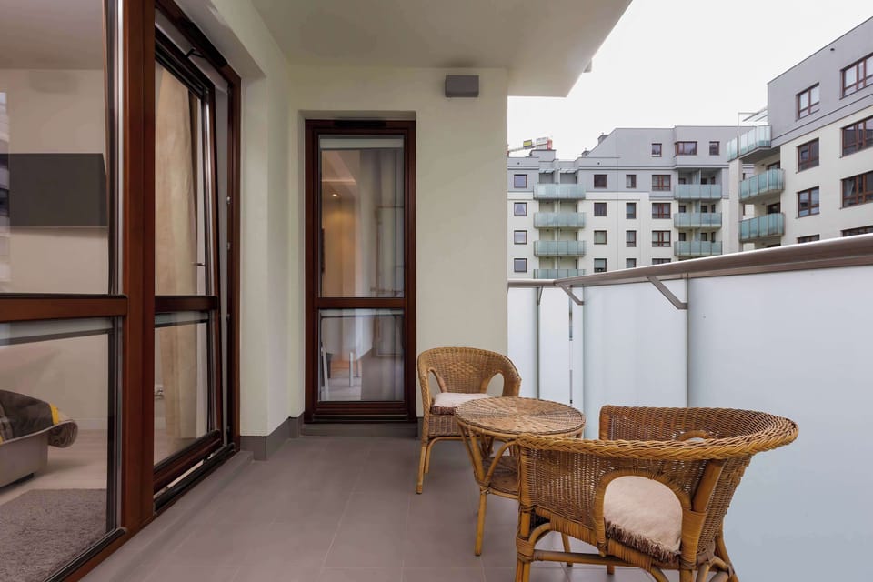 Spacious balcony with outdoor furniture. 