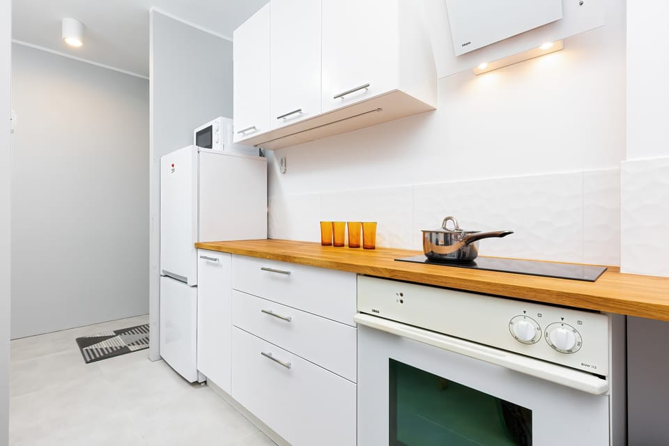 A kitchen with an oven and hob and a fridge provides a place to prepare meals.