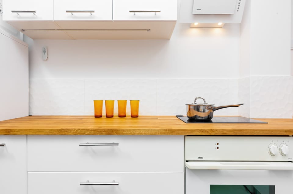 The wooden worktop in the kitchen blends perfectly with the white furniture.