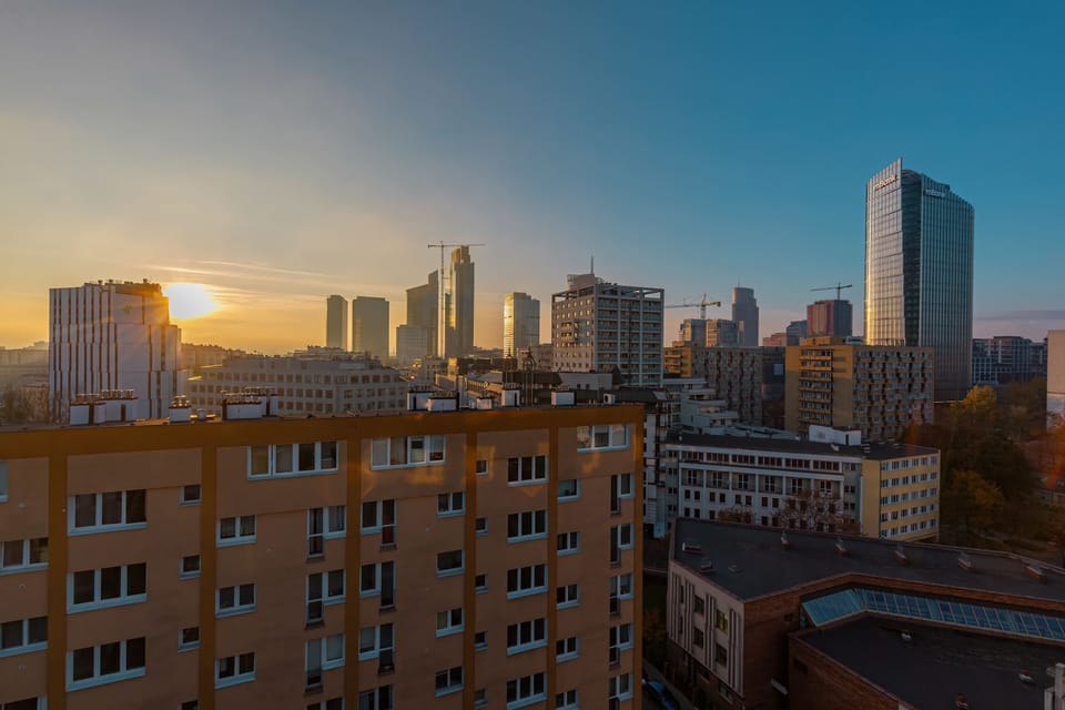 Another breathtaking city view, this time at dusk. The sky is a mix of warm sunset colors, and the buildings are softly illuminated, creating a beautiful scene.