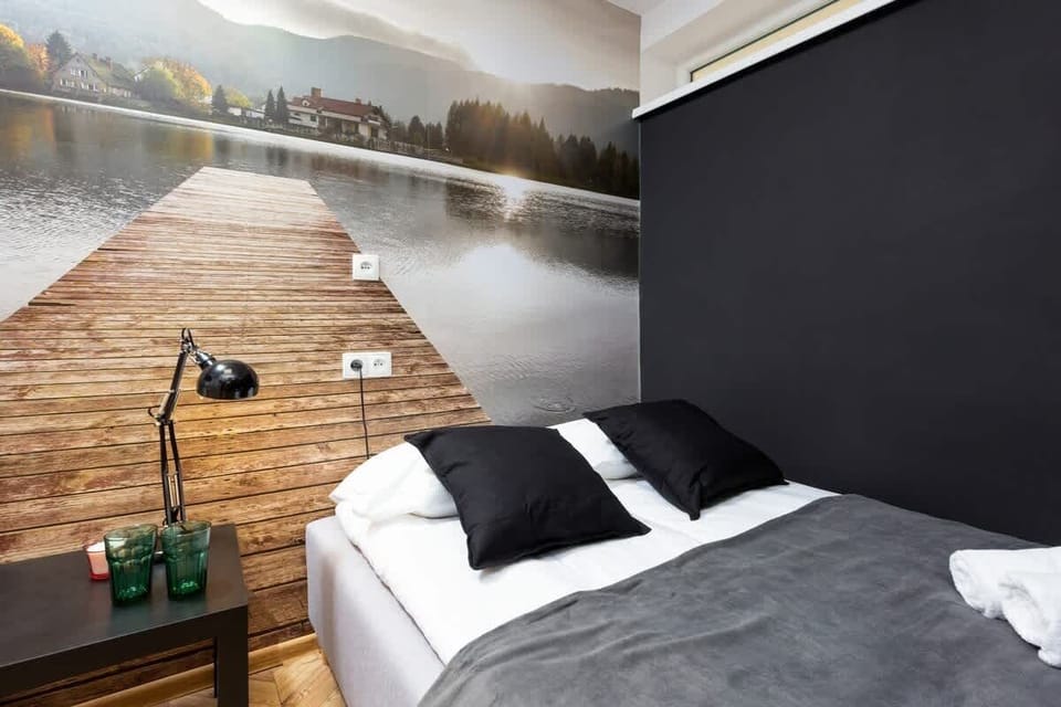 A black-tiled sleeping area with a low bed and folded towels, giving off a hotel-like vibe.