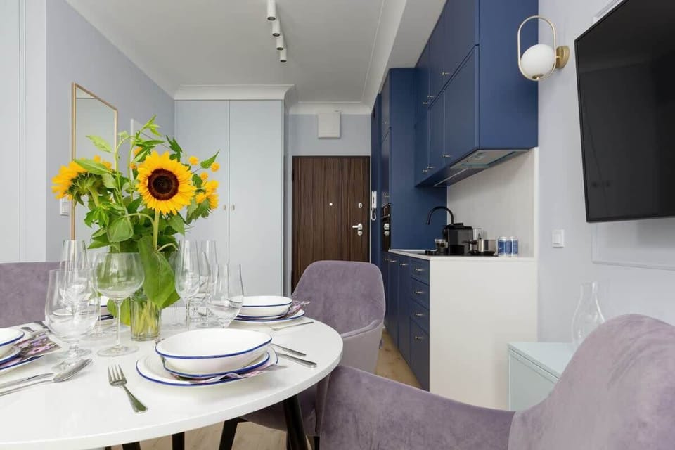 Dining table with tableware and kitchenette.