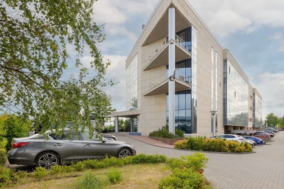 A modern apartment complex with large glass panels and lush landscaping, offering a welcoming atmosphere.
