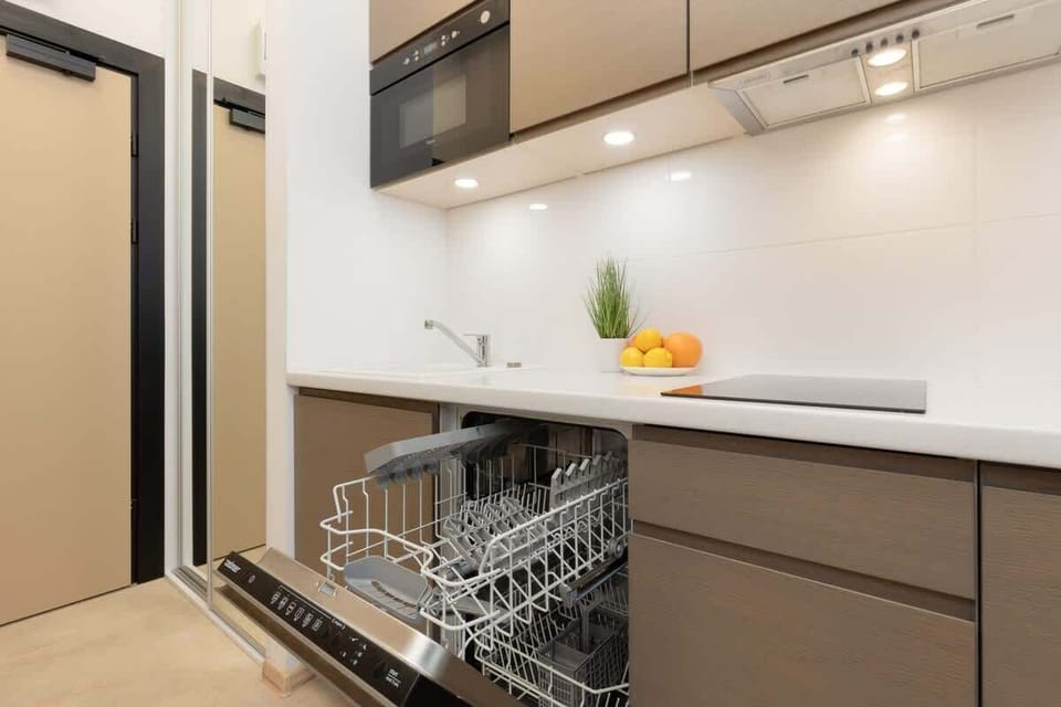 A well-equipped kitchen featuring a dishwasher, sink, and bright, functional workspace.

