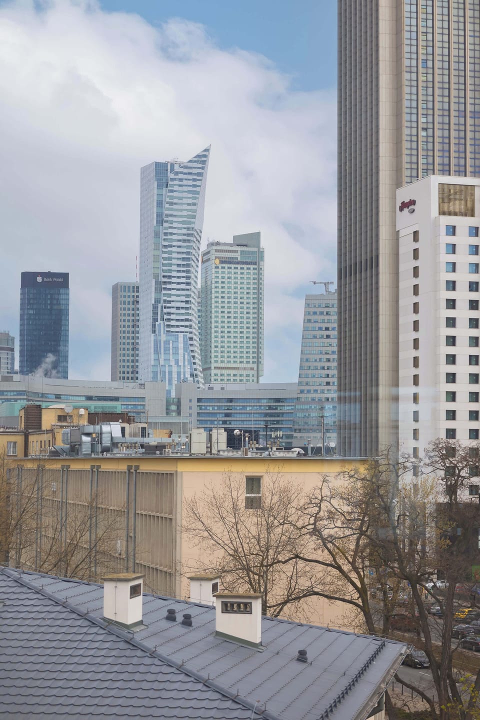 A window view showing tall buildings and a bright skyline. A beautiful city scene from above.