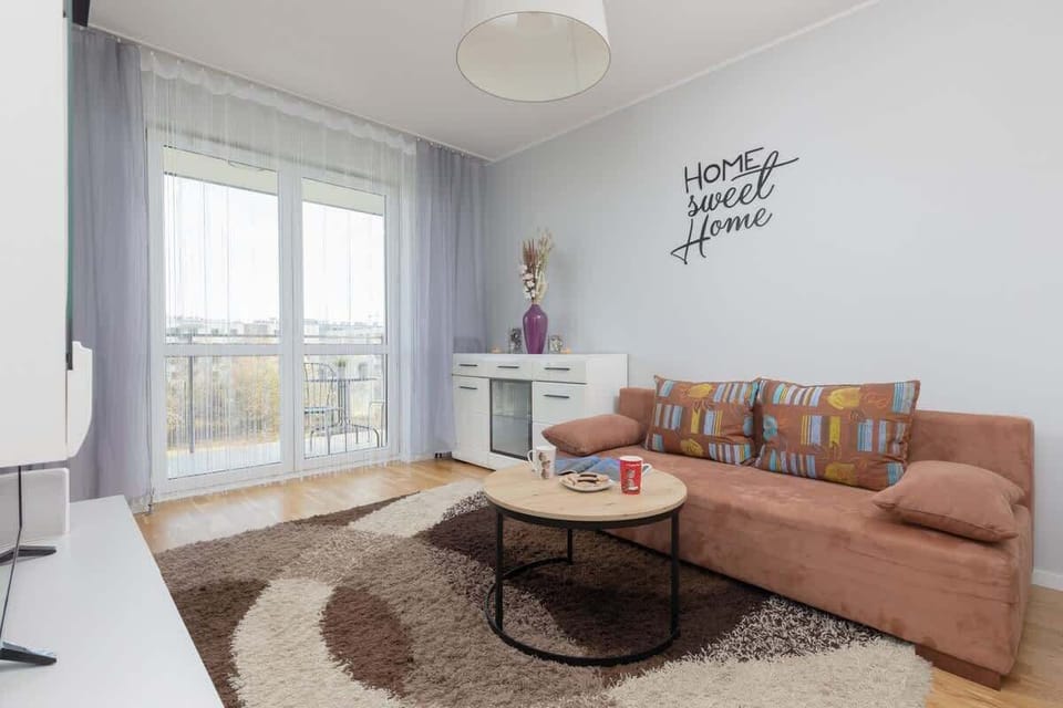 Bright living room with corner sofa, round coffee table, and open layout.