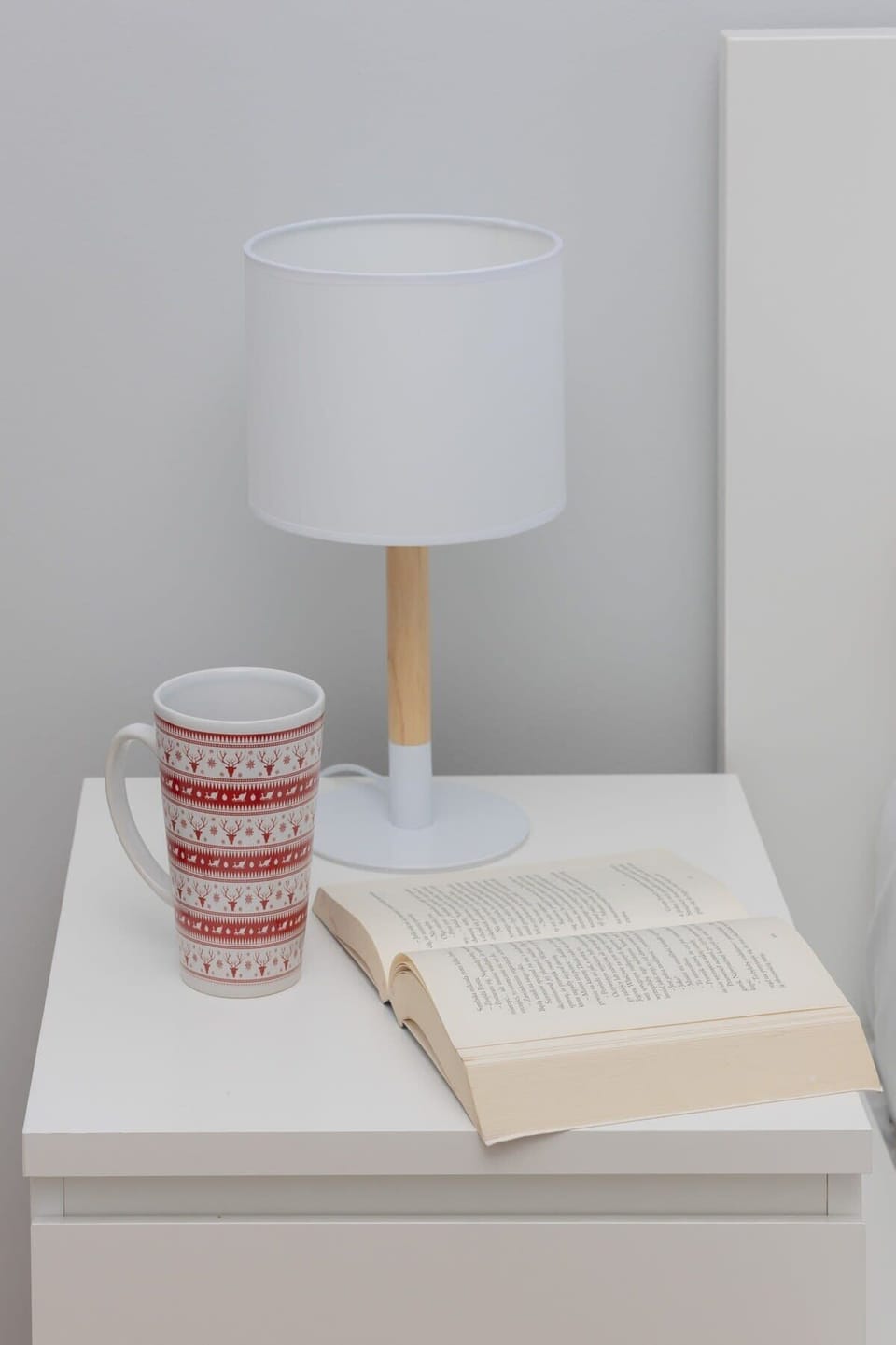 Bedside table with lamp and simple styling.