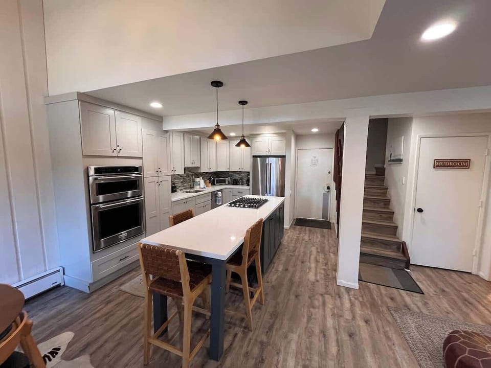 Full kitchen with stainless steel appliances, gas stove, quartz counters and bar seating for 3.  Outlets next to bar seating with USB-A and USB-C ports.