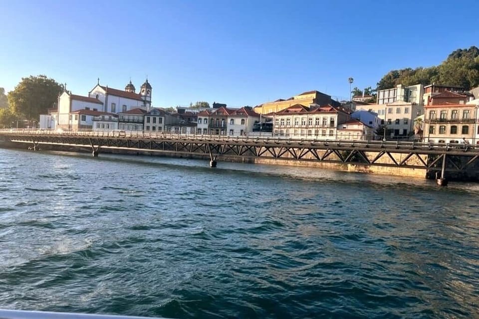 foto tirada no barco no centro do rio
foto da igreja do ano 1380
foto do jardim romantico na parte  superior da foto
ponte moderna sobre o rio
dia luminoso de Portugal