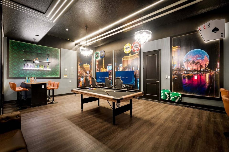 A one-of-a-kind Vegas-style game room featuring a pool table, bar seating, PS5 gaming stations, and stunning floor-to-ceiling casino artwork.