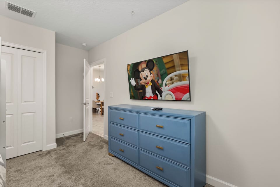 Kid-friendly dresser and a TV with classic Disney on deck.