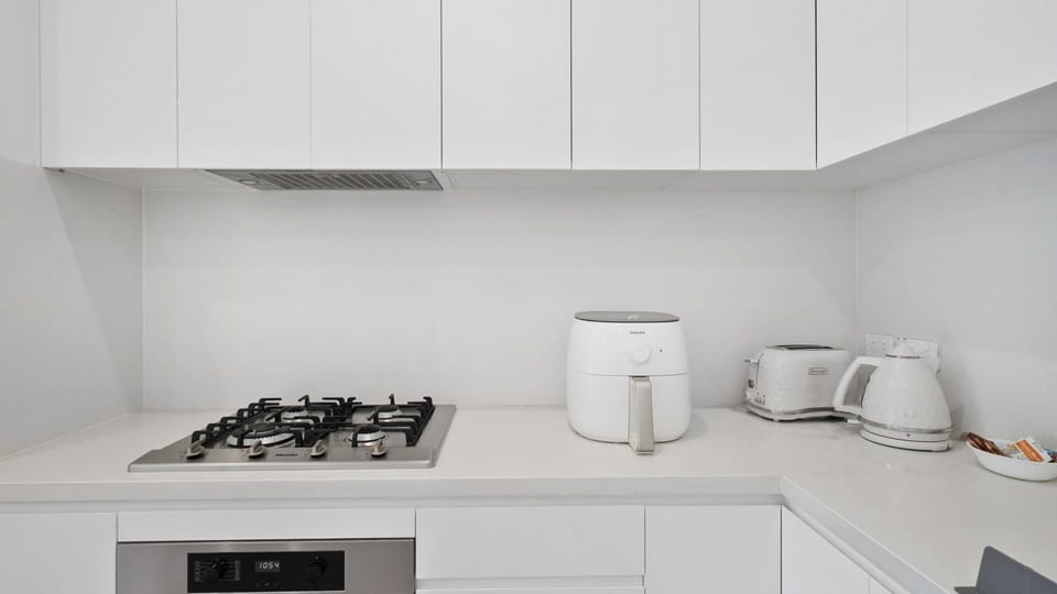 Where culinary adventures begin: A pristine kitchen featuring essential appliances.