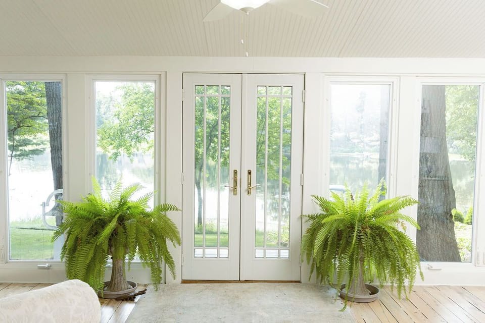 Sunroom w/ lake views, natural light & seating - perfect for relaxing year round