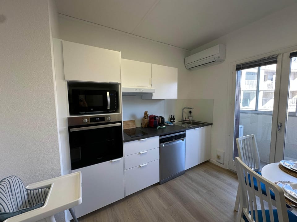 kitchen, microwave, oven, table, dishwasher, coffee machine, kettle, toaster, air conditioning