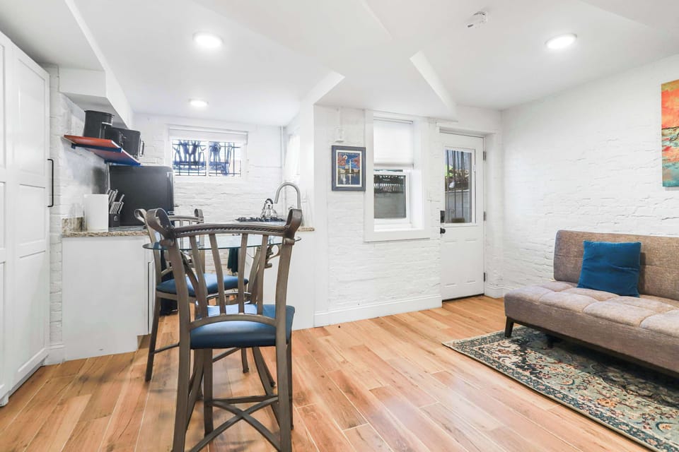 Living room area, dining area, kitchen, and front door entrance with additional storage. 