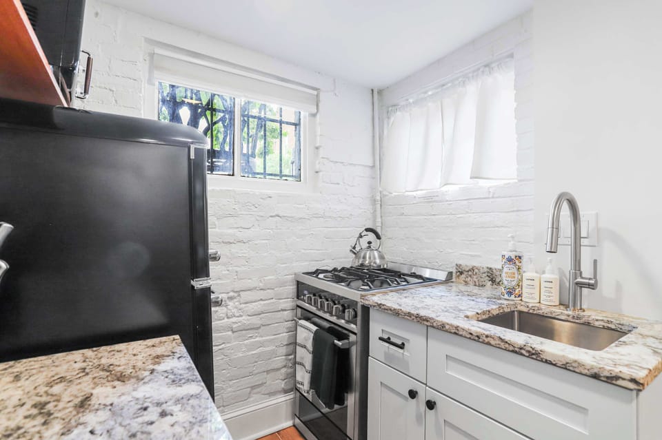 Kitchen with view of oven, stove, sink, refrigerator, and provided soap. 