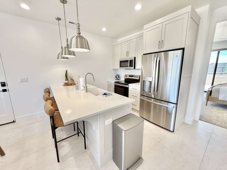 Fully equipped modern kitchen with stainless steel appliances and breakfast bar seating — cook and gather with ease!