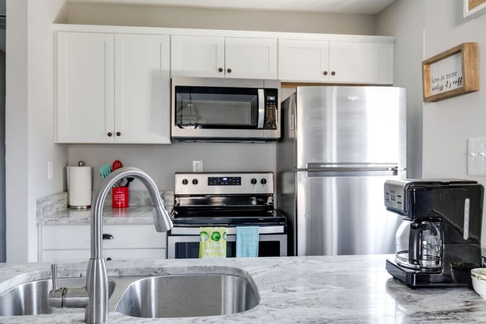 Whip up meals with ease in this fully stocked kitchen featuring a double basin sink, stove, microwave, dishwasher, and fridge. Bar seating and coffee essentials (Keurig + drip maker) make it both functional and inviting!