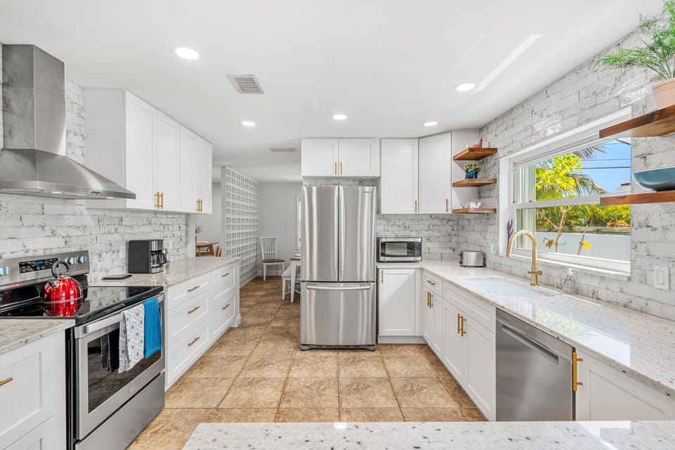 Clean kitchen with big fridge, oven, and lots of counter space to cook.