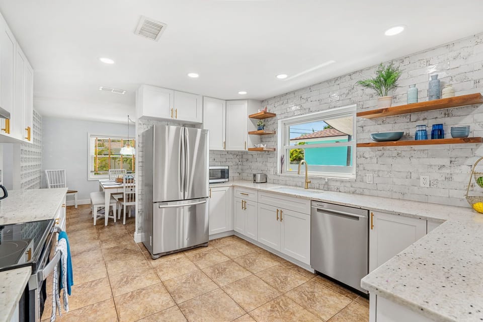 Full kitchen with big fridge and sunny window views.