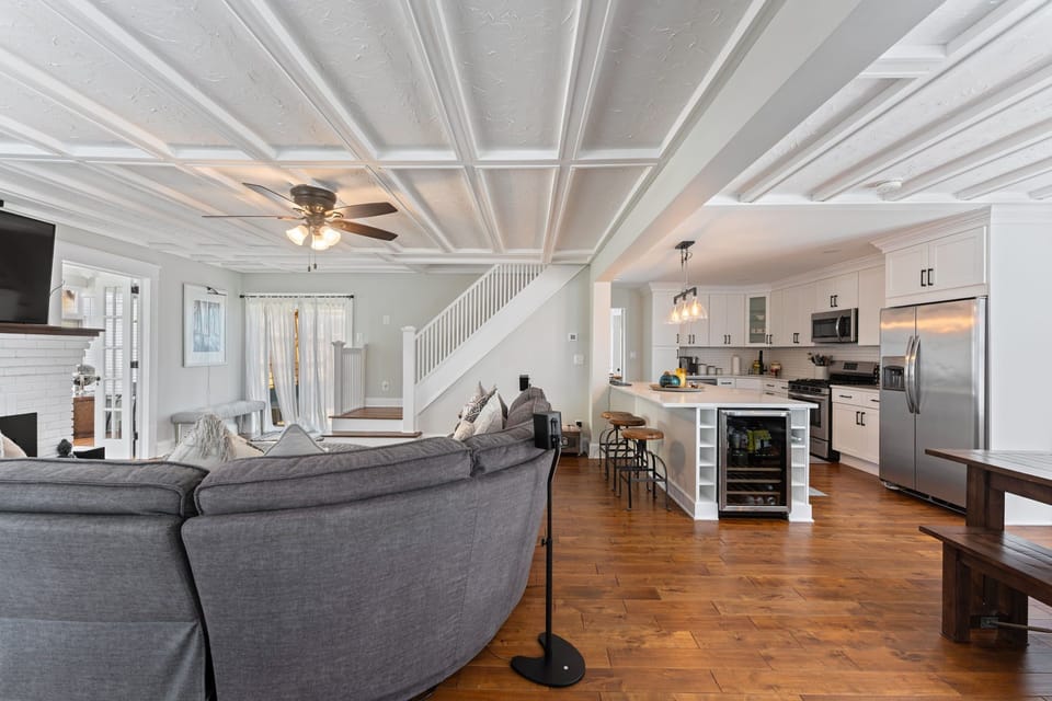Features include elegant hardwood floors, a striking white coffer ceiling, and a ceiling fan for comfort.