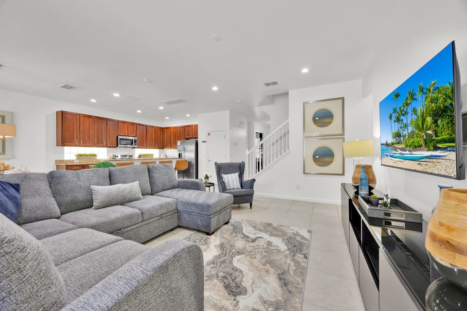 Relax and recharge in this spacious, sun-filled living room—complete with a comfy new sectional, flat-screen TV, and plenty of space to kick back after a day of Florida fun.