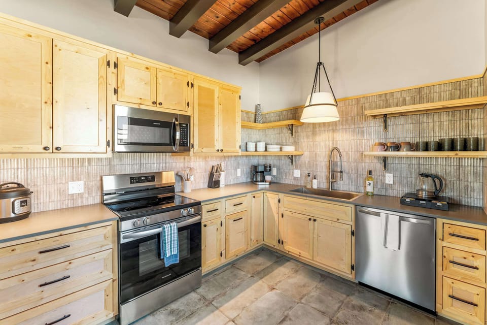【Kitchen】Full galley view — range, microwave, dishwasher, all stocked