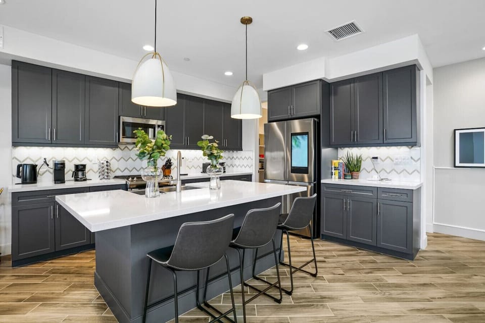 Gourmet kitchen: dark cabinets, a spacious island, and elegant pendant lights