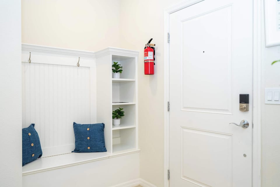 Unwind in the bright entry nook with comfy seating and cheerful blue pillows-an inviting modern space to kick off your shoes and feel at home!