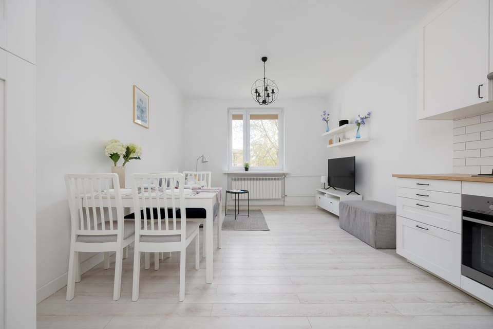 The dining area with a simple, elegant table and fresh flowers offers a delightful spot for home-cooked meals.