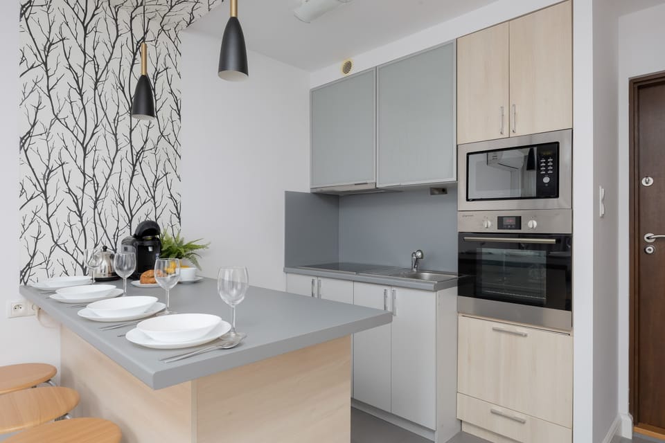 Dining area and fully equipped kitchenette with electric cooktop.