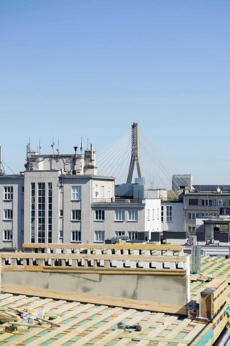 A wide-angle view from a balcony showing rooftops and buildings in the distance.