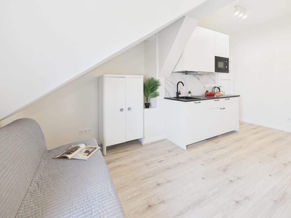 A bright and functional kitchenette featuring minimalist design and open shelving. Ideal for quick meals and effortless organization.