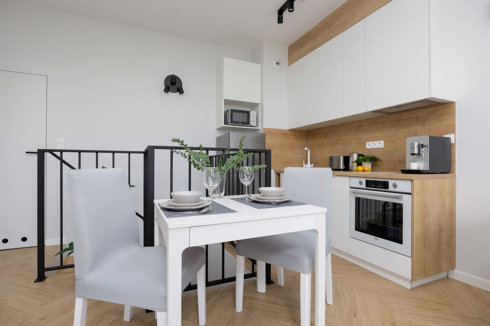 The open kitchenette with a wooden countertop and access to the dining area creates a friendly and practical cooking space.
