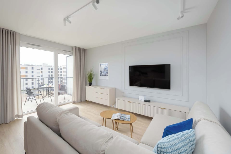 The lounge area with large windows and balcony access is perfect for morning coffee in natural light.