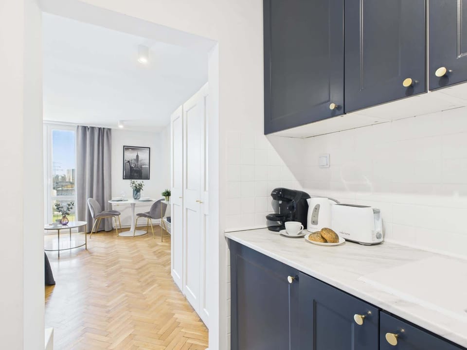 A kitchen perspective leading into the living space, showing the seamless connection between cooking and lounging areas.

