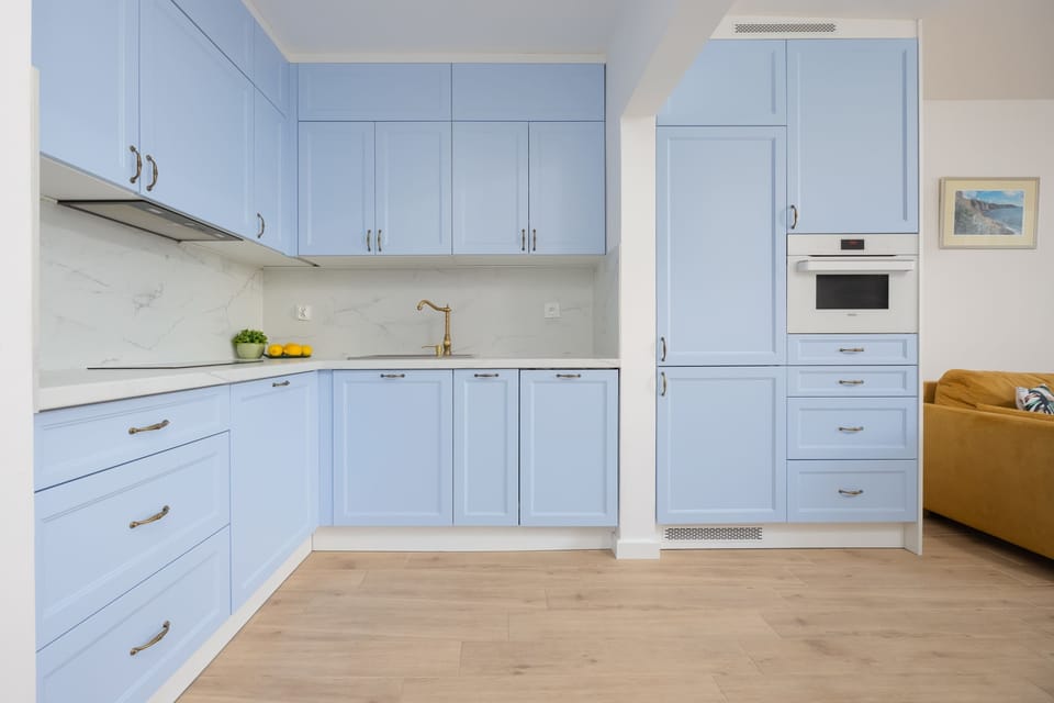 A pastel-toned kitchen with a spacious countertop and full equipment makes cooking a breeze.