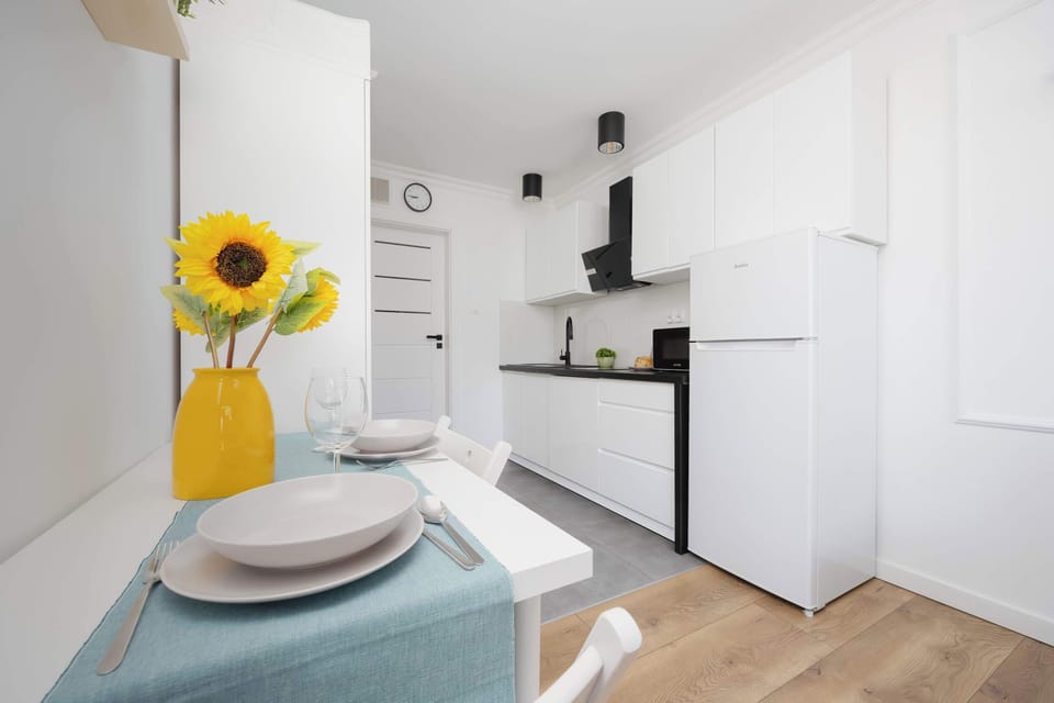 A minimalistic kitchenette setup with a built-in stovetop and microwave beside a modern door.