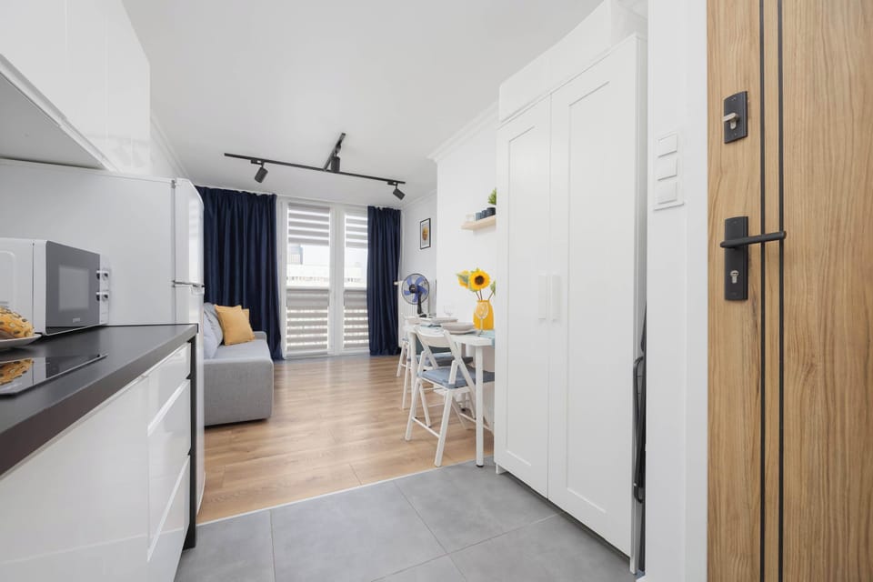 A long hallway view of the apartment showcasing the flow from the entry through the kitchen to the sleeping area.
