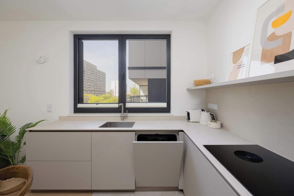 Compact kitchen with white countertops and modern appliances – Efficient and clean layout for your convenience.
