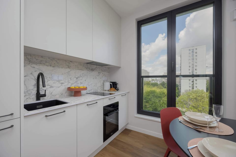 Bright, modern kitchenette with induction hob, oven, refrigerator, freezer, electric kettle, coffee maker (capsule), toaster and dishwasher.