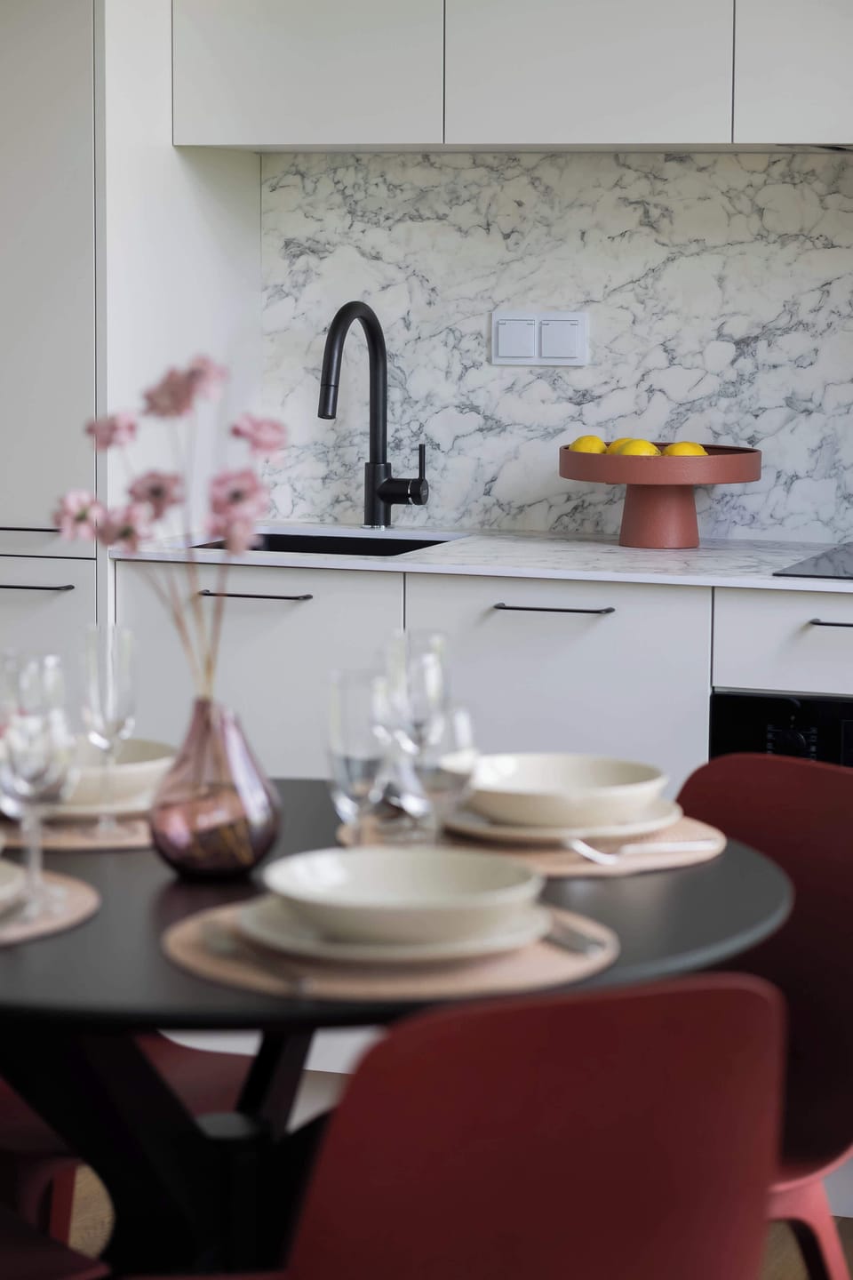 Kitchenette and dining table with tableware.