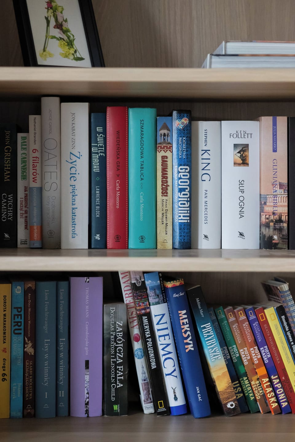 A close-up of a bookshelf filled with books and decorative objects. The warm tones of the wood complement the room's overall decor.