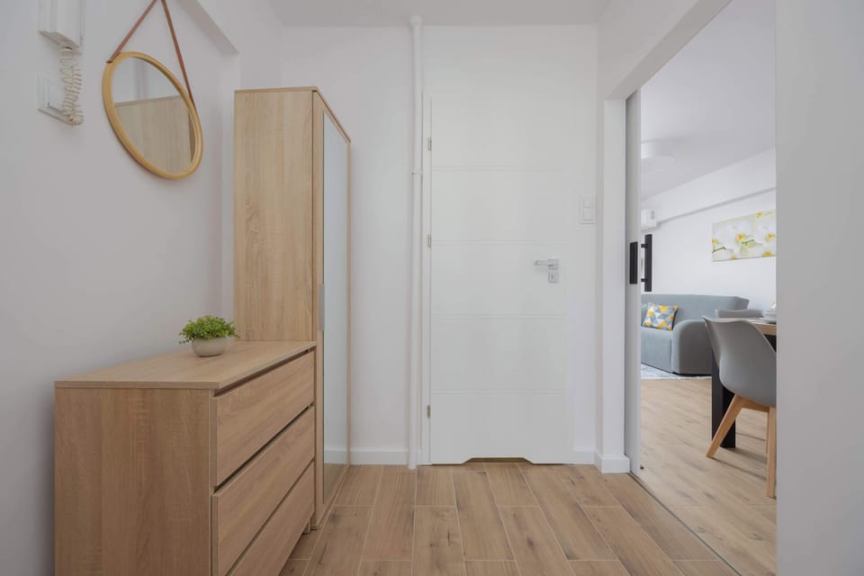 A hallway with twin wardrobes, clean white design, and natural wooden accents.

