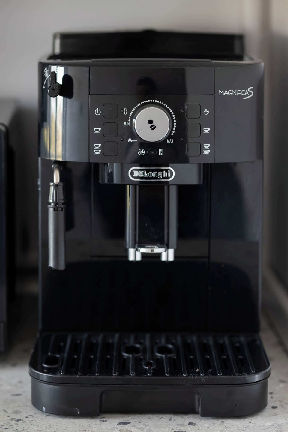 A black espresso machine ready for a fresh morning brew, standing on a counter.

