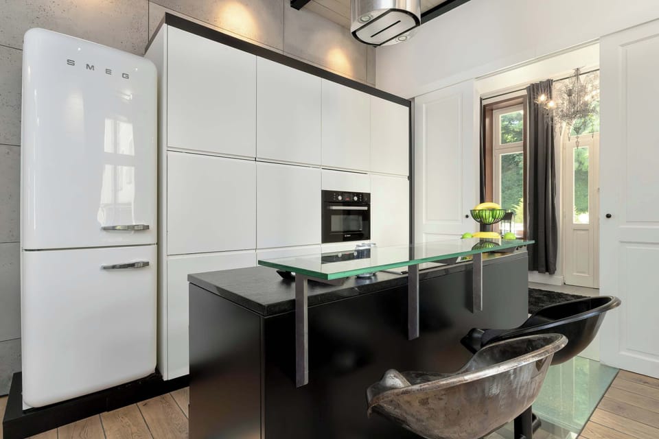 A functional kitchen with white cabinetry and wooden countertops. Includes a stove, sink, and storage space.