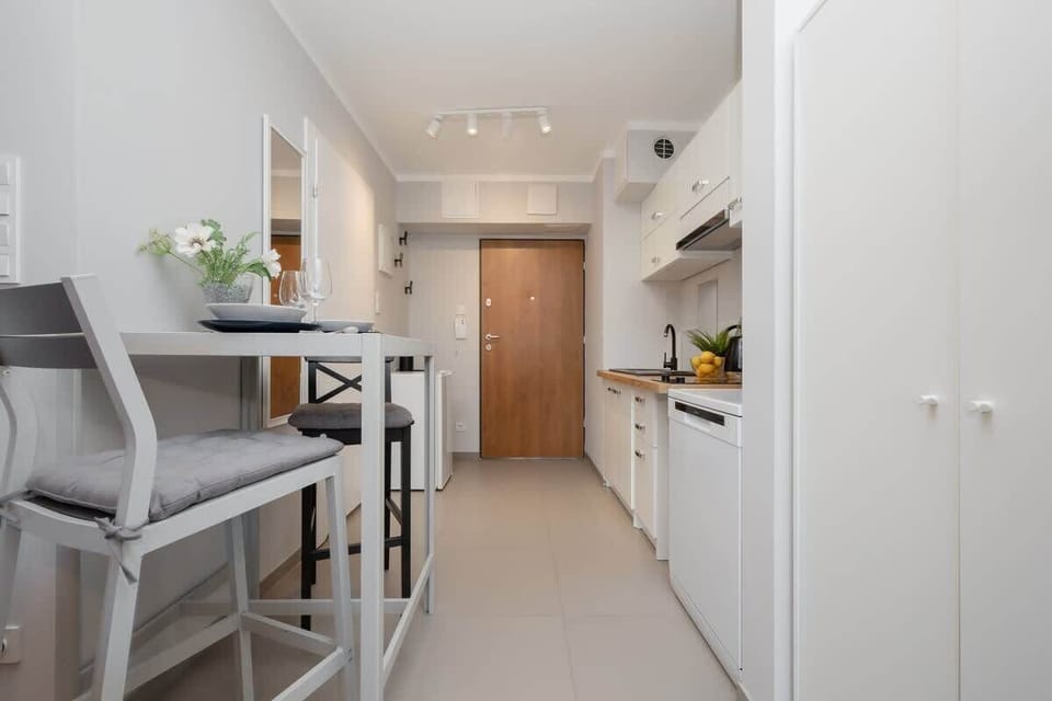A bright and airy hallway with built-in white cabinets, leading to the entrance door, enhancing storage options.

