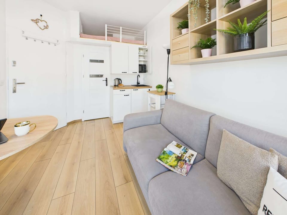 A close-up of the gray sofa with a green accent pillow, surrounded by modern shelving. The neutral colors create a harmonious look.
