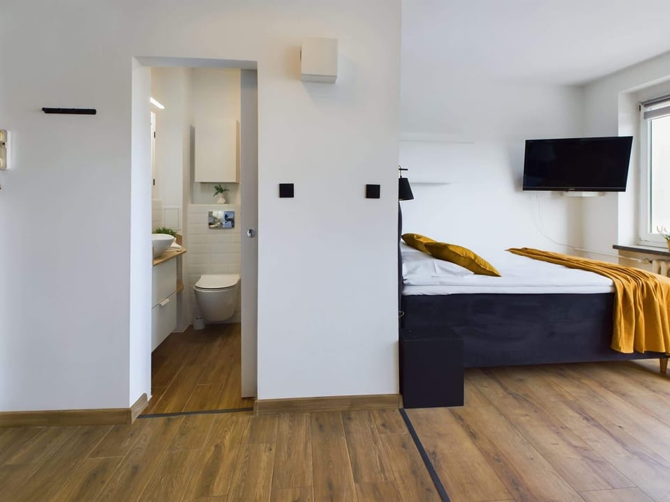 A comfortable double bed and SmartTV and entrance to the bathroom.