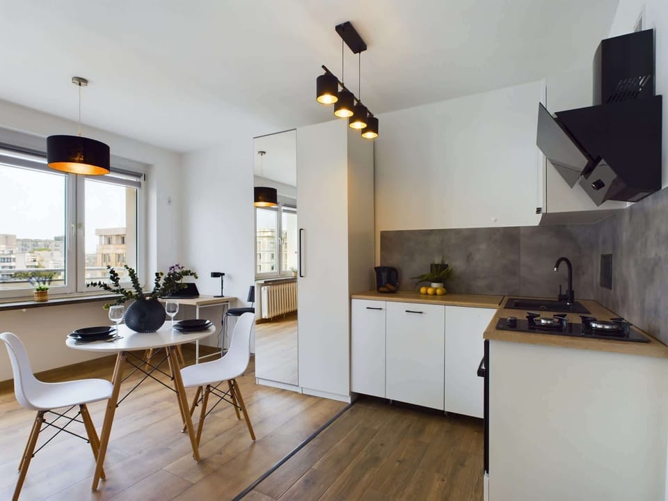 Comfortable living room with kitchenette, table for two and spacious wardrobe.